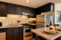Modern kitchen with black cabinets, stainless appliances, and a granite island set for two with wine, glasses, and candles.