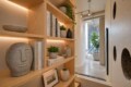 Wooden built‑in shelves with books, ceramic vases, and small plants in a bright modern hallway.