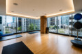 Bright urban fitness studio with large windows, wooden pillar, and yoga mats on a light wood floor overlooking a cityscape.
