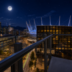 Night city view from a balcony: glowing streets, glass buildings, and a lit stadium with a distinctive roof under a full moon.
