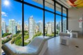 Indoor spa lounge with two curved mosaic-tile chaise lounges facing floor-to-ceiling windows overlooking a sunny city skyline.