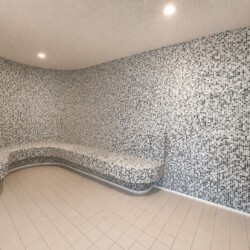 Curved mosaic-tiled steam room with built-in bench along the walls, illuminated by recessed ceiling lights.