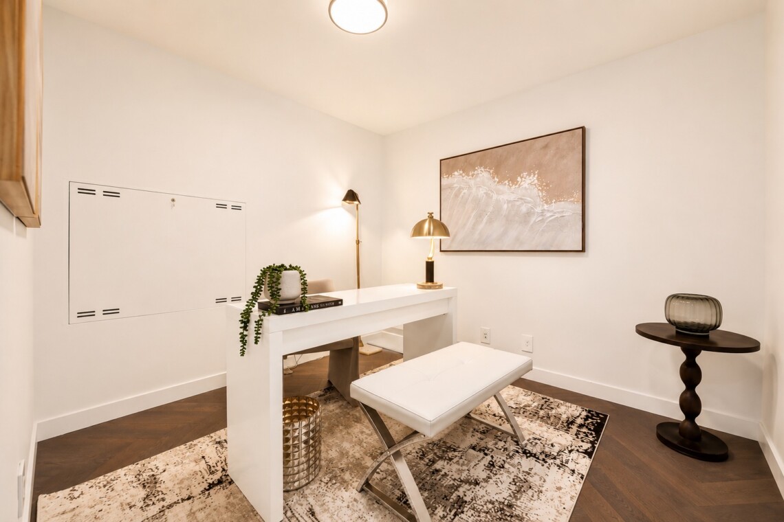 White modern home office with a sleek desk, bench seating, and a framed wave artwork on the wall