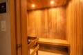 Wood-paneled sauna interior with long benches along the walls and warm overhead lighting.