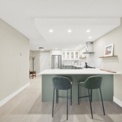 Modern kitchen with an island and three green bar stools facing the counter; light wood floor and beige walls.