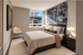 Contemporary bedroom with a dark wood platform bed, beige bedding, and a large black-and-white cityscape photograph above the headboard.