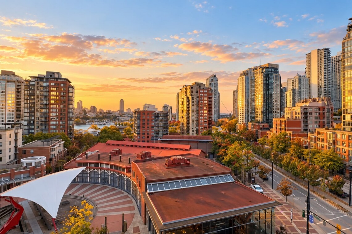 Sunset over a modern city skyline with tall glass towers, a red-roofed building, and a white tensile canopy in a plaza foreground.