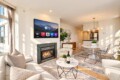 Open living room with Apple TV above a gas fireplace, beige sofa, and marble coffee table with wine."','Sunlit round marble dining table with clear chairs and a modern chandelier; kitchen in the background."','Tall windows, neutral tones, potted plant, and patterned area rug under seating."','Wine bottle and two glasses on a marble coffee table in a bright contemporary living space."','Neutral-toned living/dining area with plants, artwork, and a cozy fireplace.