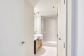 Modern bathroom with a white vessel sink on a wooden vanity and a glass shower enclosure.